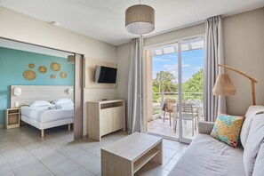 Una habitación de hotel moderna con cama, escritorio, televisor, sofá y balcón con mesa y sillas.