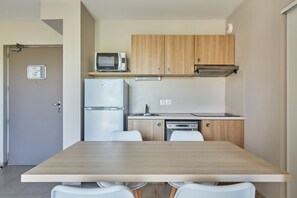 Una cocina compacta con microondas, refrigerador y lavavajillas.