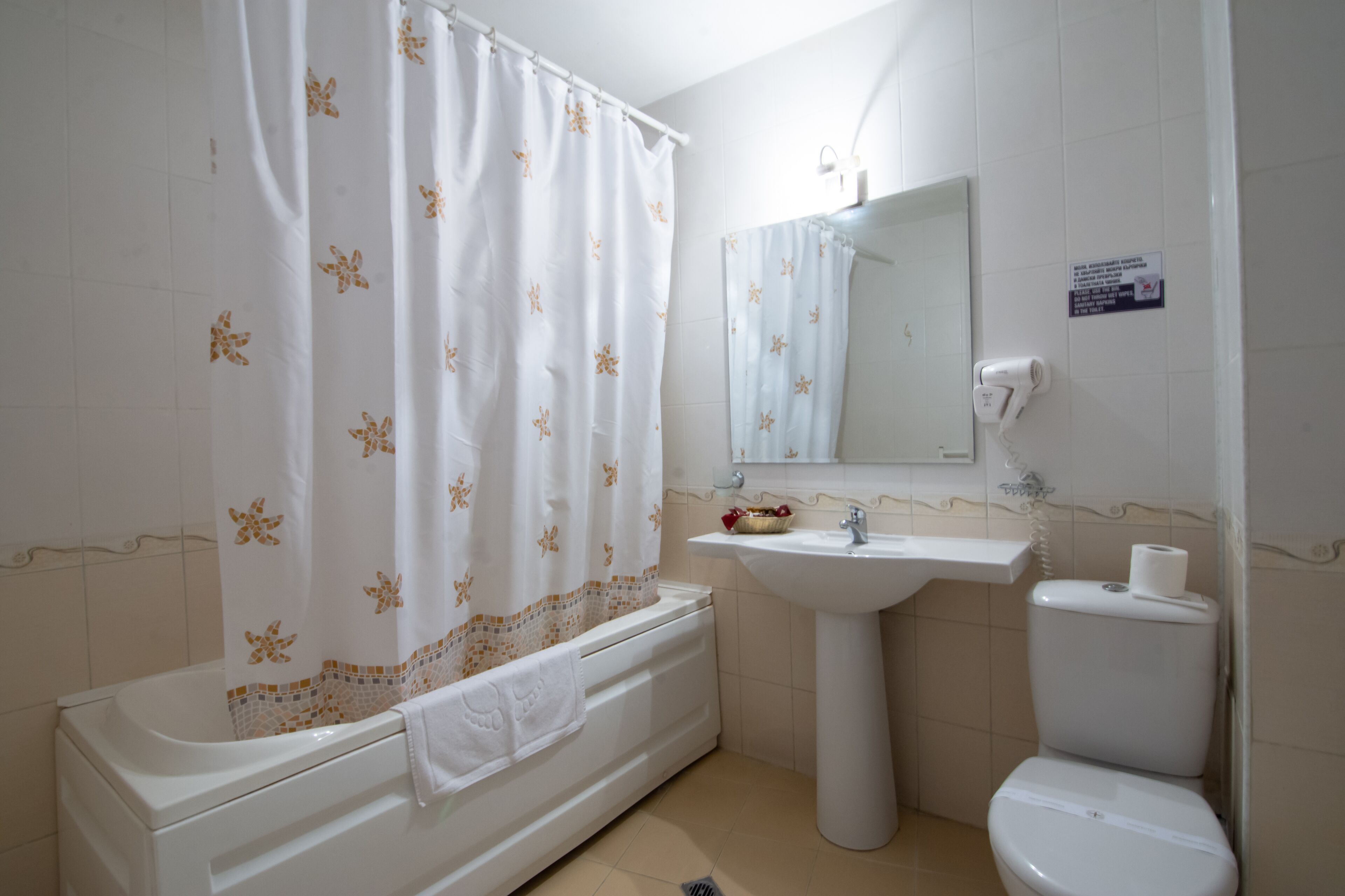 Un baño con bañera, lavamanos e inodoro.