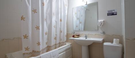 Un baño con bañera, lavamanos e inodoro.