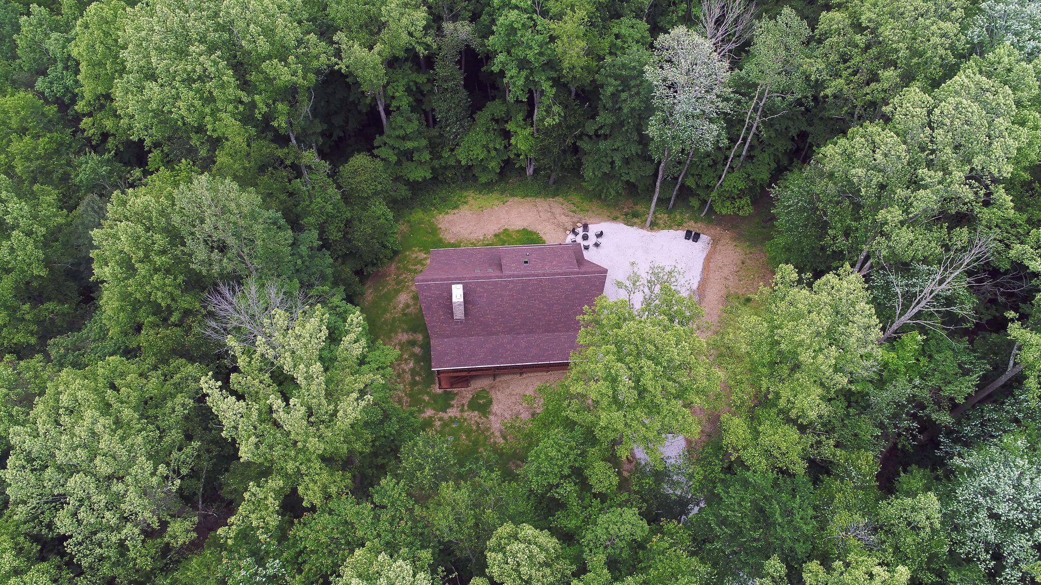 A single-story building surrounded by dense forest.