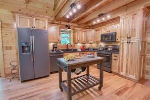 Une cuisine moderne avec des meubles en bois, des appareils électroménagers en acier inoxydable et un îlot central.