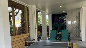A ping pong table with wheels, labeled "prince," in an outdoor area with a wooden fence and chairs. - Suite A - 3 minutes walk to Center of Folly Beach, across from beach-1 Room (Folly Beach)