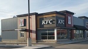 Un restaurant KFC au design moderne, doté de grandes fenêtres et d’un logo KFC bien visible.