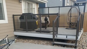 Un patio couvert aménagé avec des sièges, un barbecue et une chaise suspendue.
