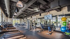 A gym with treadmills, weight machines, and exercise balls.