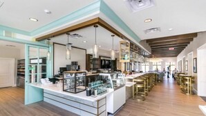 A spacious kitchen with a central island, pendant lighting, and a bar area with stools.