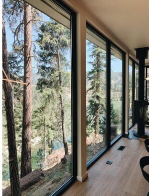 Enjoy expansive views of the forest from the large windows in this serene space.