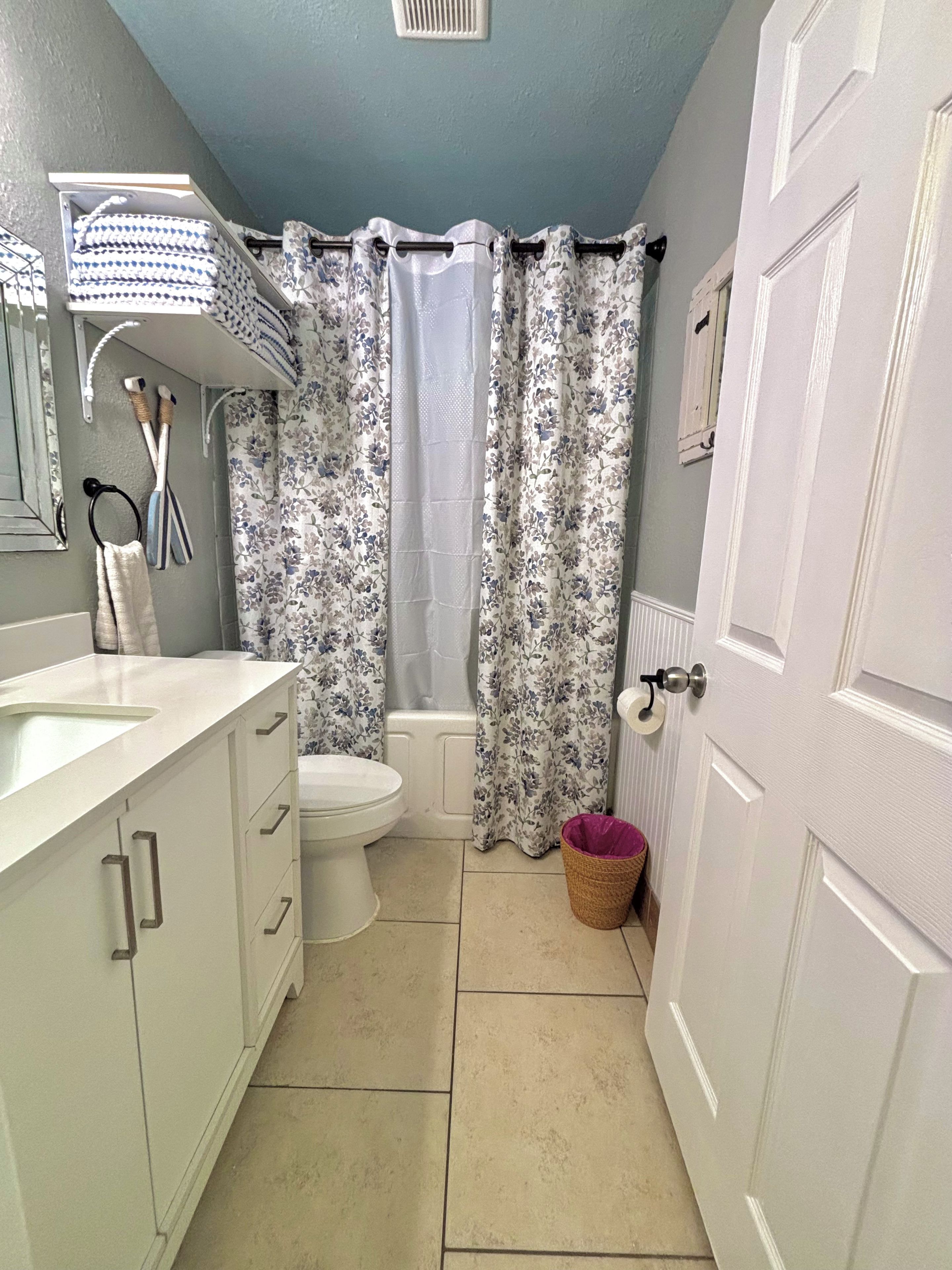 A bathroom with a toilet, sink, and shower curtain.