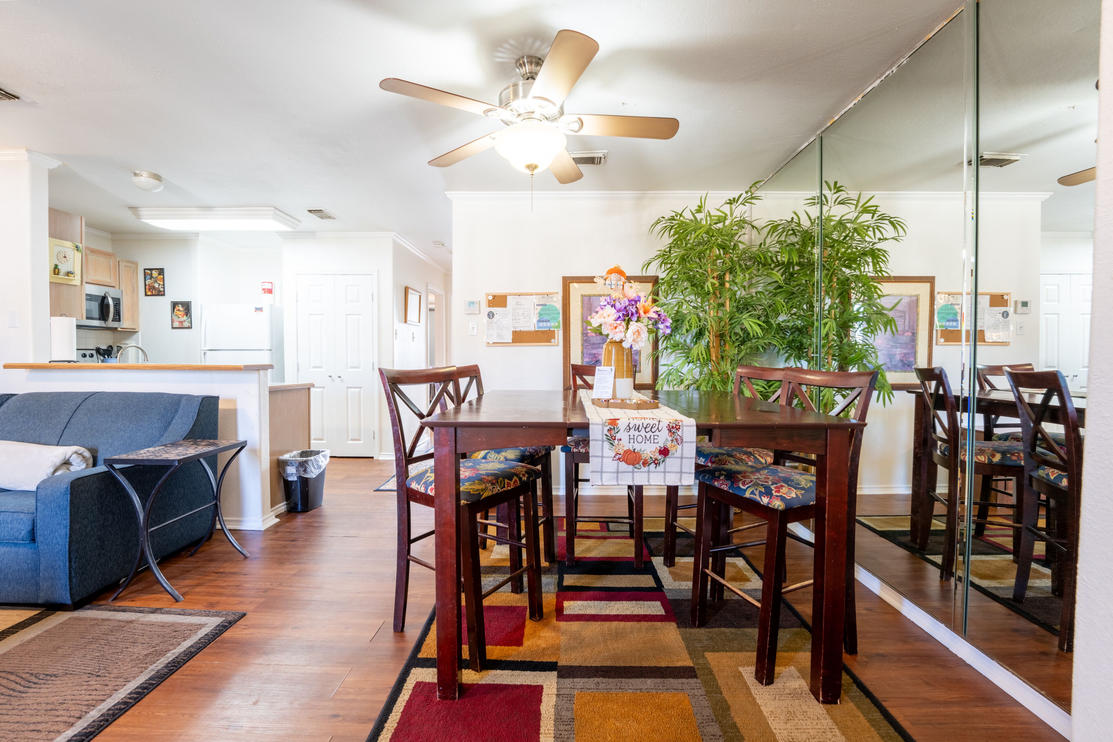 A modern kitchen with a microwave, refrigerator, and a ceiling fan.