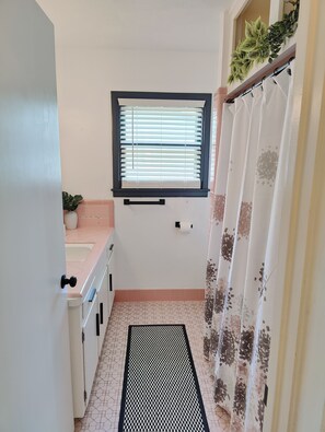 Une petite salle de bain avec une fenêtre, des toilettes et un lavabo.