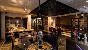 A modern interior with a bar area, seating, and wine racks. - Luxurious Silicon Valley Condo: Rooftop Lounge and Pool (Menlo Park)