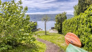 Un sendero que lleva a un lago con barcos y abundante vegetación.