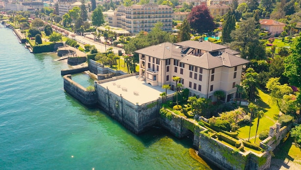 A waterfront property with a large building, a dock, and surrounding greenery. - Wonderful Stresa apartment on the lake in Stresa (Stresa)