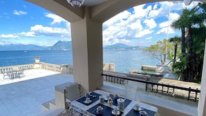 A terrace with a table set for tea, overlooking a body of water and mountains. - Wonderful Stresa apartment on the lake in Stresa (Stresa)