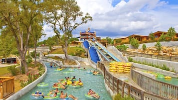 A water park with a large water slide, multiple water channels, and inflatable rafts.