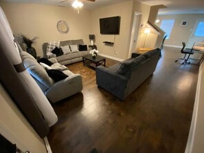 Relax in this inviting living space with a large sofa, flat-screen TV, and cozy coffee table.