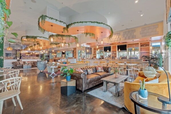 Un hall d’entrée spacieux, doté d’un canapé en cuir, de chaises en bois et d’un coin bar.