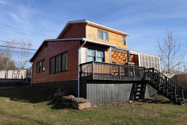 Et toetagers træhus med en balkon og en trappe, der fører op til etageplanen.