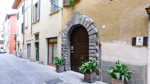 Una calle adoquinada con un arco de piedra que da paso a un edificio con una puerta marrón.
