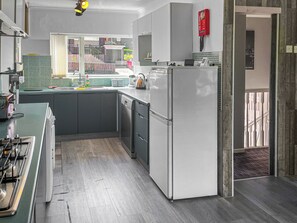 Uma cozinha moderna com fogão a gás, lava-louças e frigorífico.