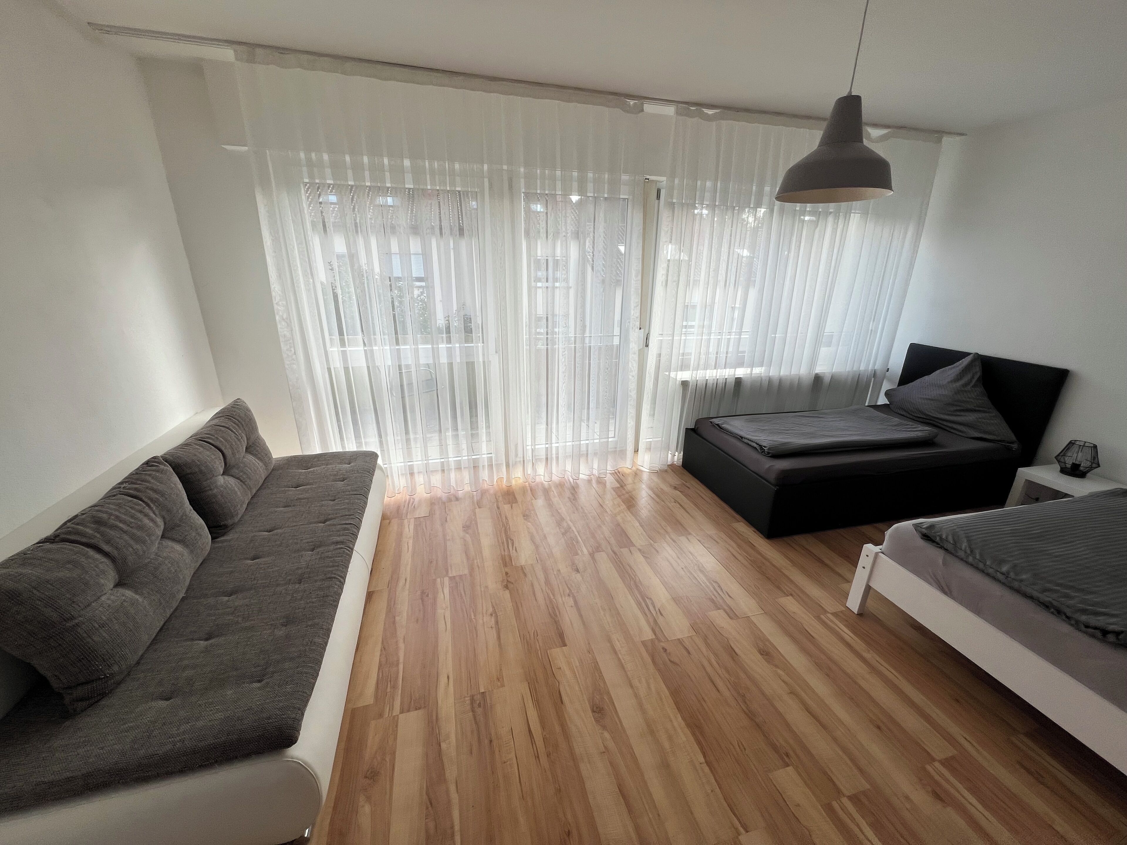 Une chambre à coucher moderne avec un canapé, un lit et une table de chevet.