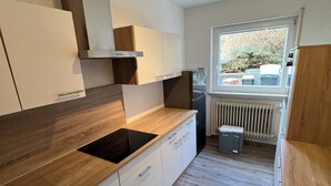 A modern kitchen with wooden countertops, white cabinets, and a built-in stove.