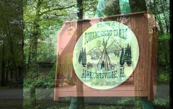 A welcome sign for Towamensing Township, featuring a teepee, mountains, and wildlife. - Cottage by the Lake, Hot Tub, Game Room, Private Pool. (Albrightsville)