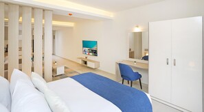 A modern hotel room with a bed, a desk, a chair, a TV, and a wardrobe. - Prime Residence New Alamein (El Alamein)