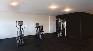 A gym with treadmills, a stationary bike, and a weight machine. - Prime Residence New Alamein (El Alamein)