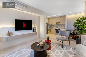 A modern living room with a flat-screen TV, a round coffee table, and a grey sofa. - Prime Residence Sheikh Zayed (Sheikh Zayed City)