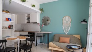Een knus woongedeelte met een kitchenette, een eethoek en een bank.