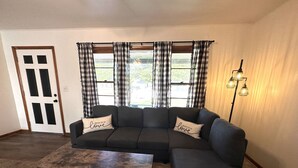 Una sala de estar con un sofá modular, una mesa de centro y una lámpara de pie.