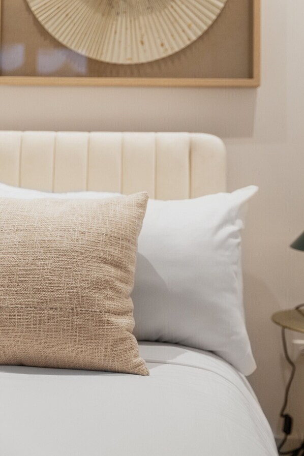 Una cama con dos almohadas, un cabecero y un adorno en la pared.