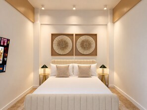 Un dormitorio con una cama grande, dos obras de arte colgadas en la pared y dos mesitas de noche con lámparas.