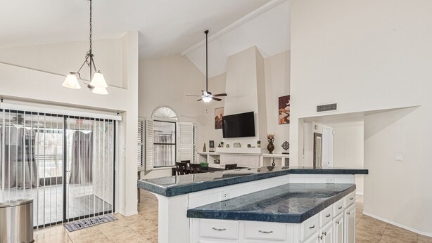 A spacious kitchen with a large island, white cabinetry, and a flat-screen TV mounted above the island. - 4 Bedroom Incredible Backyard with Pool! (Glendale)