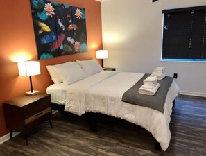 Relax in a stylish room with a large bed, bedside tables, and a beautiful painting above.