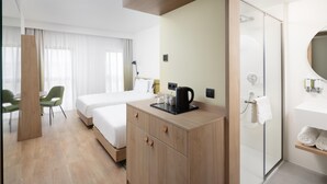 A hotel room with a bed, a desk, a coffee maker, a shower, and a bathroom with a mirror and towel rack. - Hampton by Hilton Targu Mures (Targu Mures)