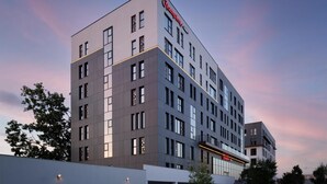 A modern hotel building with a prominent 'Hampton' sign, multiple floors, and a flat roof design. - Hampton by Hilton Targu Mures (Targu Mures)
