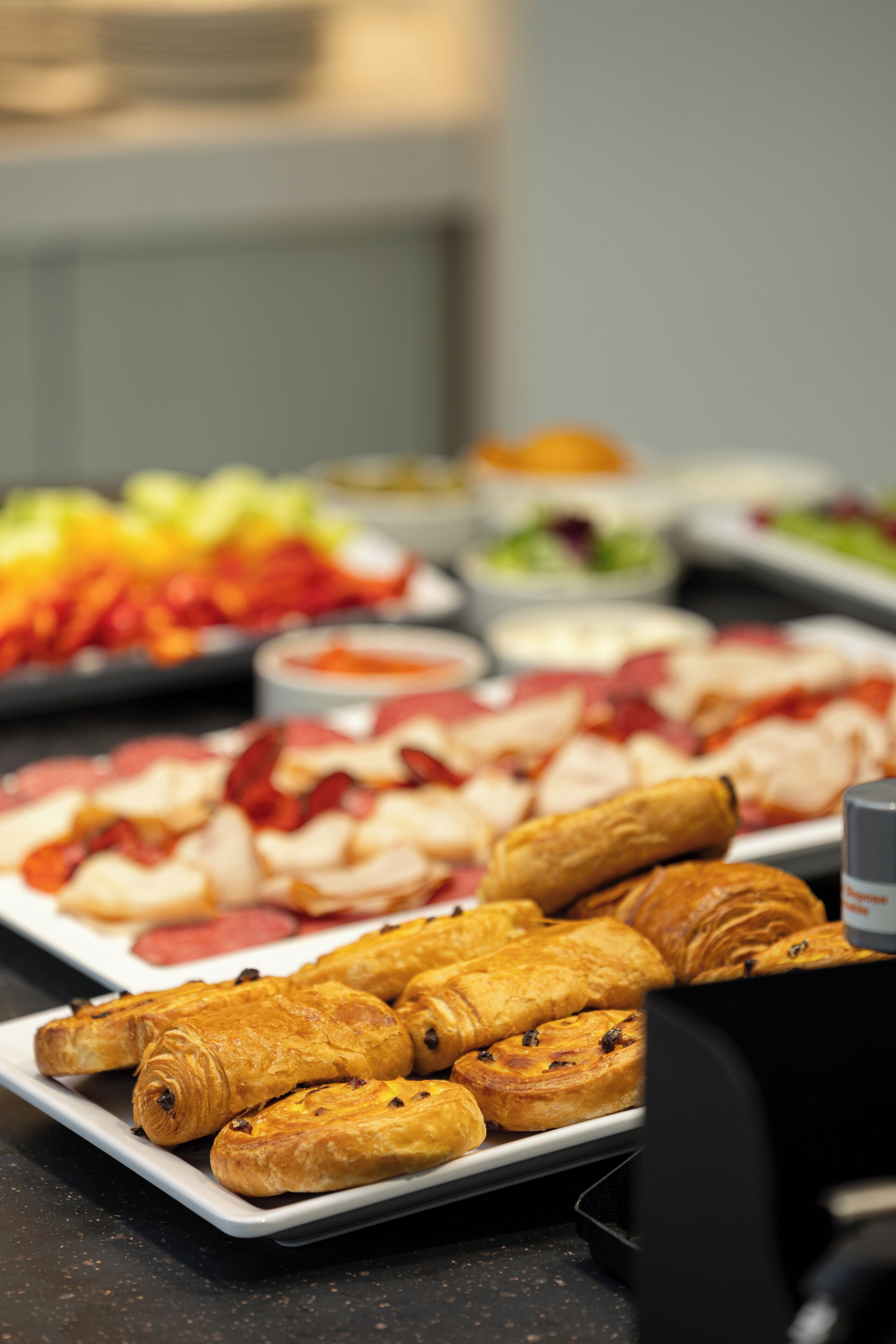 Buffet com diversos alimentos, incluindo doces, carnes e vegetais.