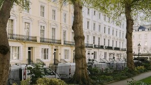 A row of white buildings with balconies, trees in the foreground, and a paved walkway. - The Voyage Hotel Paddington  (London)