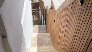 A set of outdoor stairs leading up to a wooden fence.