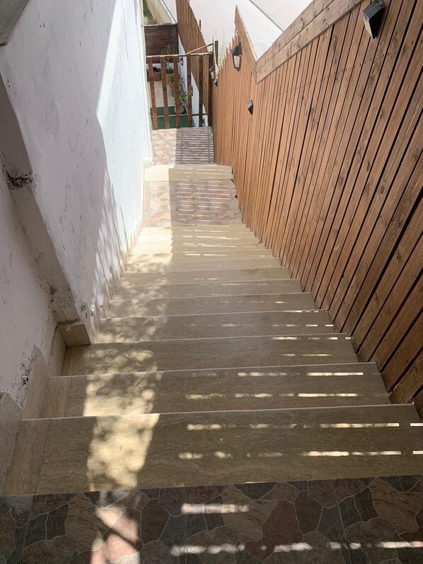 Eine Treppe führt nach draußen zu einem hölzernen Zaun.