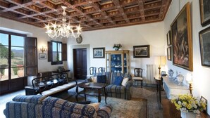 Un vaste salon doté d’un haut plafond en bois, d’un lustre et d’une grande fenêtre donnant sur l’extérieur.