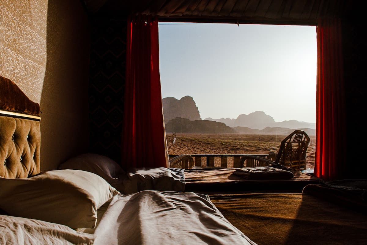 Une chambre avec un lit, une chaise et une vue sur un paysage désertique.