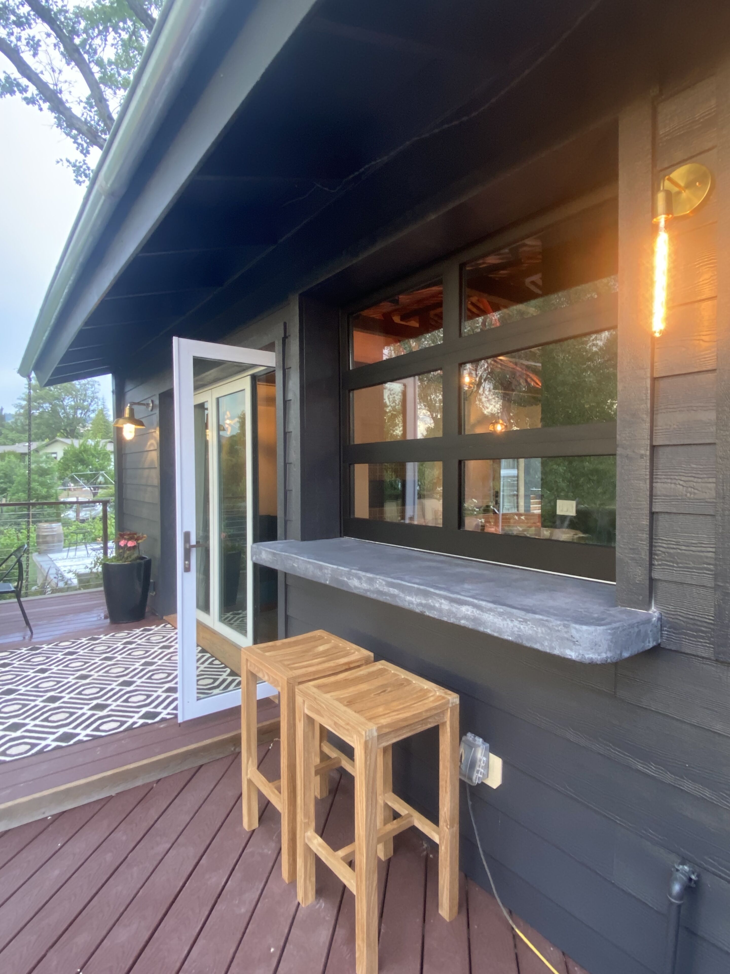 Outdoor bar that connects with indoor bar with garage door-window.