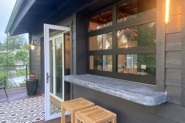 Outdoor bar that connects with indoor bar with garage door-window.