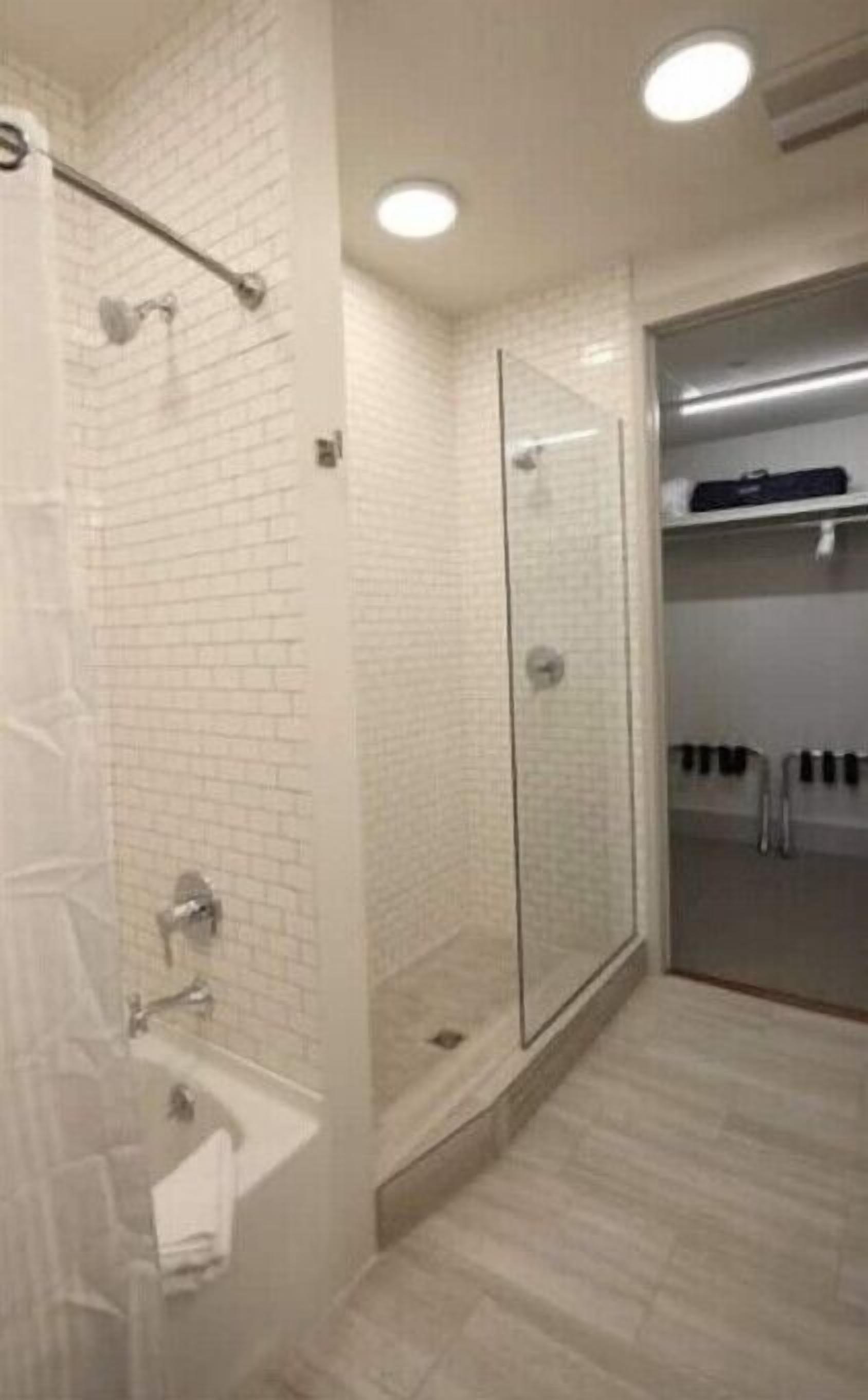 A modern bathroom with a glass shower enclosure, a white bathtub, and a walk-in shower.