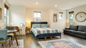 A bedroom with a bed, a sofa, a desk, and a chair.