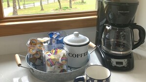 Een keukentrap met een koffiezetapparaat, een mok en een bakje yoghurt.